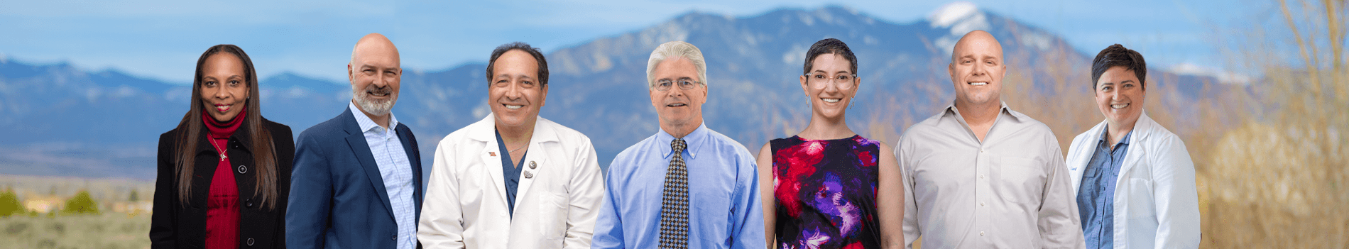 Team of healthcare professionals from Holy Cross Surgical Specialties standing together with mountains in the background.