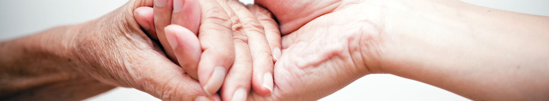Two hands of different ages interlocked, symbolizing support and connection in benefit navigation.