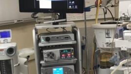 Surgical video tower setup featuring a monitor and multiple medical devices in an operating room environment.
