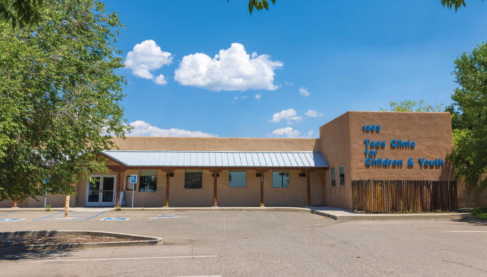 Taos Clinic for Children & Youth building exterior, featuring a welcoming entrance and ample parking space.