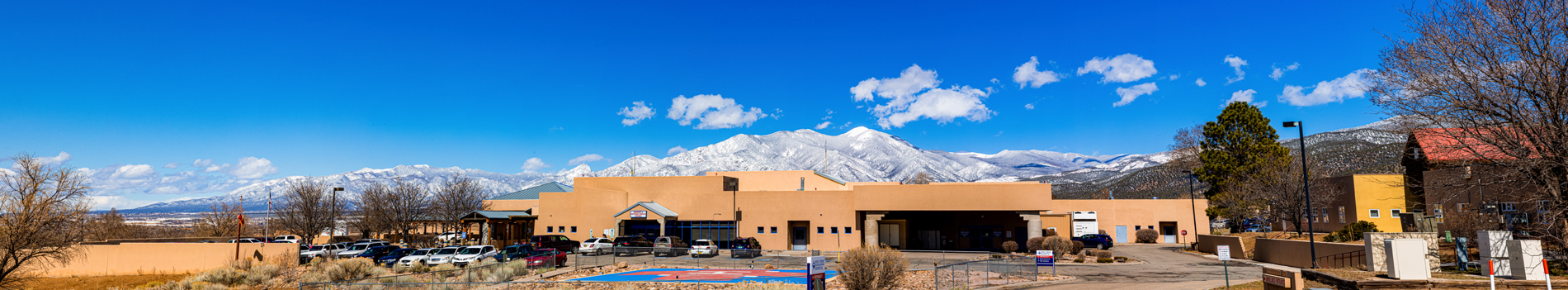 Holy Cross Medical Center building with mountains behind it in winter.